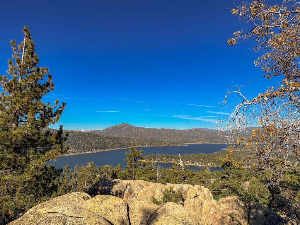 Scenic panoramic view of Big Bear Lake and surrounding pine forests taken from the rocky summit of Castle Rock Trail